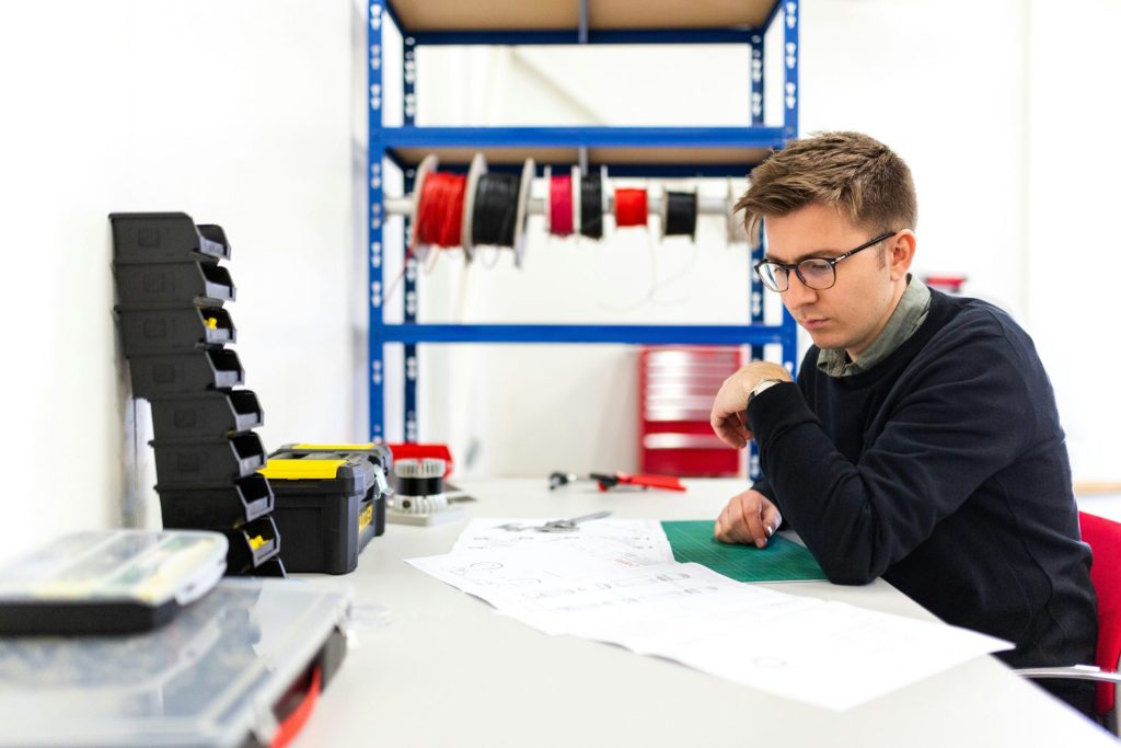 Junge im schwarzen Kapuzenpullover schreibt auf weißem Papier